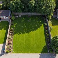 A backyard with a lawn and a fence photo
