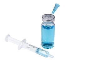 Syringe, medical vial with light blue vaccine and injection needle photo