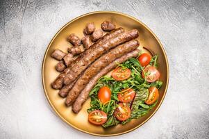 Close up of perfectly charred grilled sausage with salad, ideal for adding flavor to your favorite dishes or sandwiches. white background. top view photo