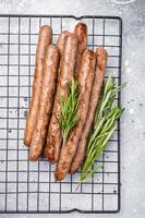 Flavorful grilled sausage links on a rack, inviting you to enjoy a hearty meal with family and friends. grey background. top view photo