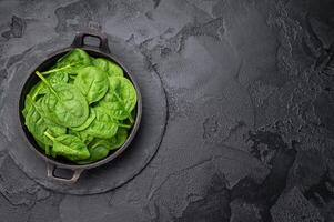 Crisp and lush fresh spinach ready for your favorite recipes, a versatile superfood for every meal. black background. top view photo