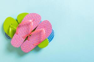 A lot of colored flip flops on blue background.Top view with copy space photo
