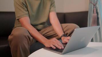 Focused productivity a person sits on a couch with focused attention, typing diligently on a laptop on a table. The atmosphere suggests a blend of relaxation and productivity video