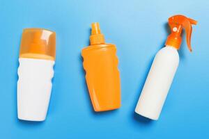 flat lay concept summer travel vacation. Sunscreen bottle mock up on blue background top view with copy space photo