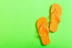 orange flip flops green background. Top view with copy space photo