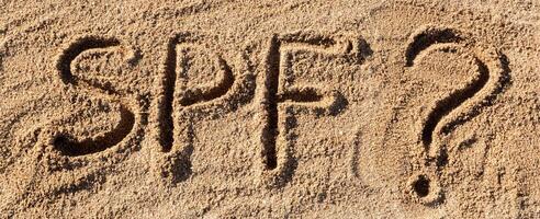 Sun protect factor concept. SPF word written beach with question mark photo