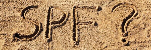 Sun protect factor concept. SPF word written the beach with question mark photo