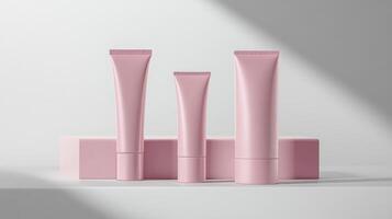 Three cosmetic tubes with pink packaging on a white surface photo