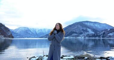 Smiling woman enjoying snowy fjord and mountain scenery in Gaupne, Norway winter photo