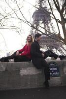 Smiling couple relaxes near Eiffel Tower in Paris photo
