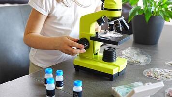 Close up view of hands of little girl preparing a sample for microscope examination. Concept of hands-on science learning and curiosity-driven exploration. High quality 4k footage video