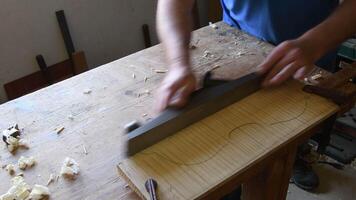 Luthier working in a new violin or viola with a wood planer video