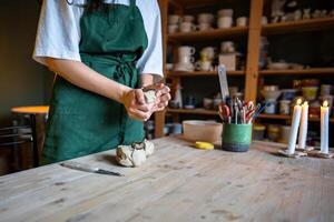 Female potter hands knead clay for craft natural ceramics in workshop. Shape materials in workshop photo