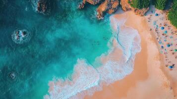 Aerial view of tropical beach, turquoise water, cliff, people relaxing photo