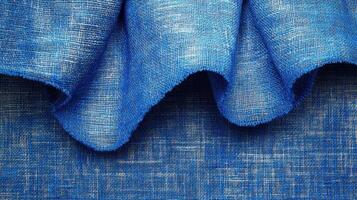 Blue linen fabric texture, draped folds, close-up shot, textile background photo