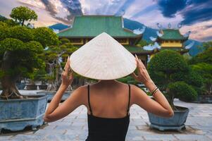 back of woman tourist traveler at Buddhist temple at Linh Ung Pagoda in Da Nang in Vietnam. Concept of travel and tourism in Asia photo