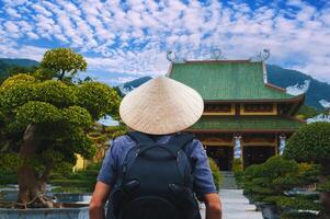 back of a male tourist traveler at a Buddhist temple at Linh Ung Pagoda in Da Nang in Vietnam. The concept of travel and tourism in Asia photo