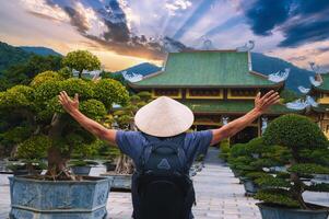 male tourist traveler at Buddhist temple at Linh Ung Pagoda in Da Nang in Vietnam. Concept of travel and tourism in Asia photo