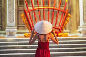 woman in traditional Vietnamese Non La hat in temple on a Buddhist pagoda in Vietnam. The concept of travel in Asia photo