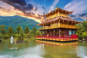 Asian Buddhist Temple on water on lake at Vietnamese Nghia Son Pagoda in Vietnam in Nha Trang in Asia at sunset photo