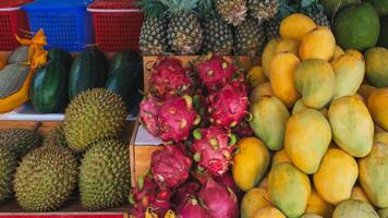 Mango, pitahaya, durian and pineapples on counter in a store in Thailand at a street market. Assortment of sweet ripe exotic tropical Vietnamese fruits photo
