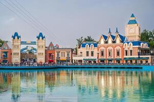 A beautiful tourist square with architectural buildings and castles by the lake in Magic City amusement park in Tashkent. Tashkent, Uzbekistan - July 15, 2025 photo