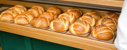 Freshly baked pastries displayed on wooden shelf, inviting and warm photo