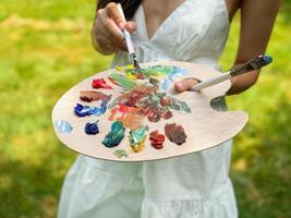 palette of paints and brushes in your hands photo
