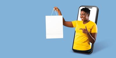 A buyer uses a large smartphone to engage in online shopping, happily showcasing a shopping bag. The setting features a clean, isolated background that emphasizes the activity. photo