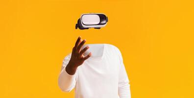 A user engages with virtual reality technology, wearing futuristic goggles and extending their hand. The vibrant yellow background enhances the modern, immersive experience. photo