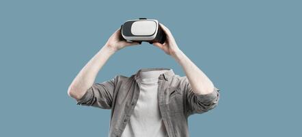 The subject engages in a virtual reality activity, wearing advanced goggles that cover the eyes. Arms reach out as they immerse in a tech-driven experience against a minimalistic backdrop. photo