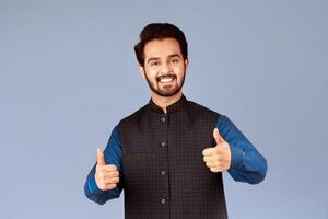 Happy Indian guy showing thumbs up gesture, expressing positivity over lilac background. Panorama photo
