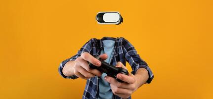 A person actively utilizes virtual reality goggles and a gaming controller with no visible head or face, set against a vibrant yellow background. The focus is on the immersive experience. photo