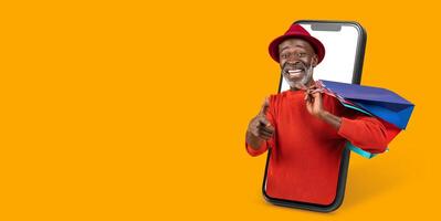 A delighted customer engages in online shopping through a smartphone application, smiling and showcasing shopping bags with a bright orange background. photo