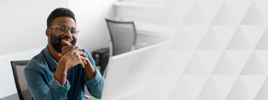A young African American manager is confidently engaging in work at his modern office. He exudes success and professionalism in his entrepreneurial environment, copy space photo