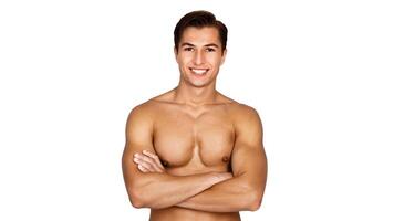 Male Model. Portrait of handsome strong athletic guy with muscular naked torso standing with folded arms, isolated over white background. Shirtless attractive man posing at studio. crossing hands photo
