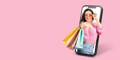 A cheerful customer holds shopping bags while using a smartphone to browse an online store. The vibrant backdrop enhances the theme of modern online commerce. photo