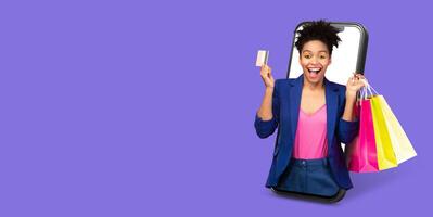 A woman joyfully holds shopping bags and a credit card, emerging from a large smartphone screen. She enjoys online shopping, showcasing excitement in a vibrant setting. photo