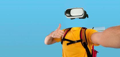A traveler wearing virtual reality goggles enjoys an immersive experience. They give a thumbs up while showcasing modern technology. The backdrop is isolated, highlighting the excitement of VR. photo