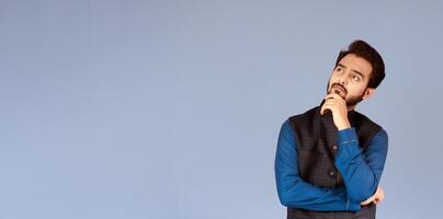 Portrait of pensive Indian man thinking over something over lilac background photo