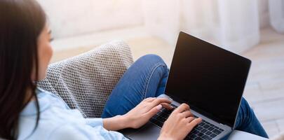 Mockup image of asian girl using laptop computer with blank screen at home, space for your design photo