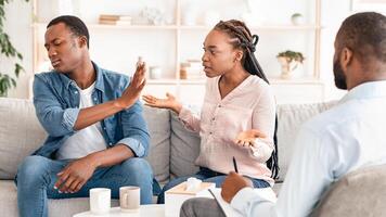 Black couple arguing in front of their therapist at session in office, having relationship problems and family issues, free space photo