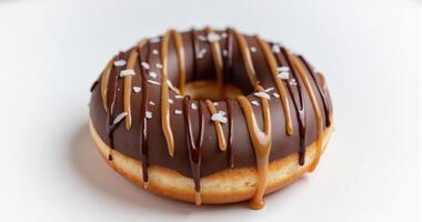 A chocolate donut with caramel drizzle on top enjoyment photo