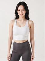 A woman in a white sports bra top and grey leggings photo