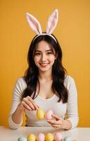 Happy woman wearing bunny ears holding colorful easter eggs photo