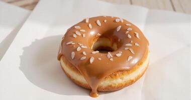A donut with caramel glaze sitting on top of a napkin photo