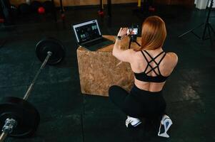 View from the back. Shooting by smartphone. Beautiful ,strong woman is in the gym photo
