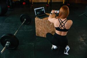 View, from the back. Shooting by smartphone. .Beautiful strong woman is in the gym photo