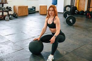 Sitting, relaxed. Beautiful strong woman is in the gym. photo
