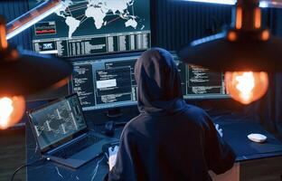 Light, bulbs.. Young professional female hacker is indoors by computer with lot of information on displays photo